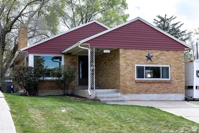 1431 Capitol St, Ogden, UT 84401 - bungalow with a chimney, brick siding, a front yard, and central air condition unit
