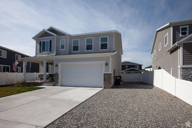 1719 N Pintail Dr Unit 60, Salem, UT 84653 - view of front of house featuring fence, driveway, stone siding, a porch, and a garage
