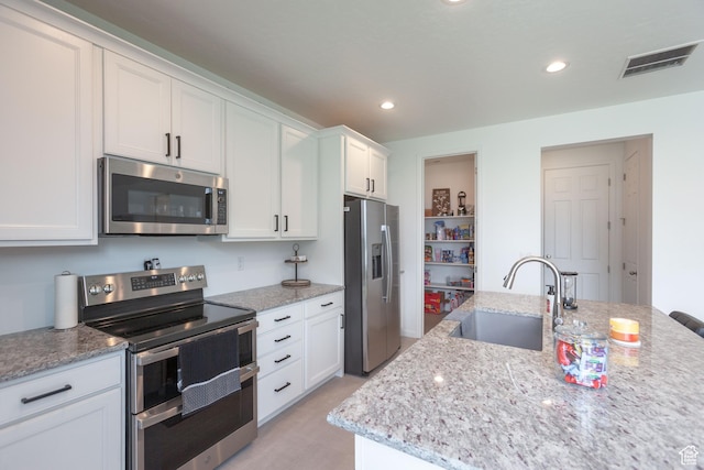 1719 N Pintail Dr Unit 60, Salem, UT 84653 - kitchen with white cabinets, light stone counters, visible vents, a sink, and appliances with stainless steel finishes