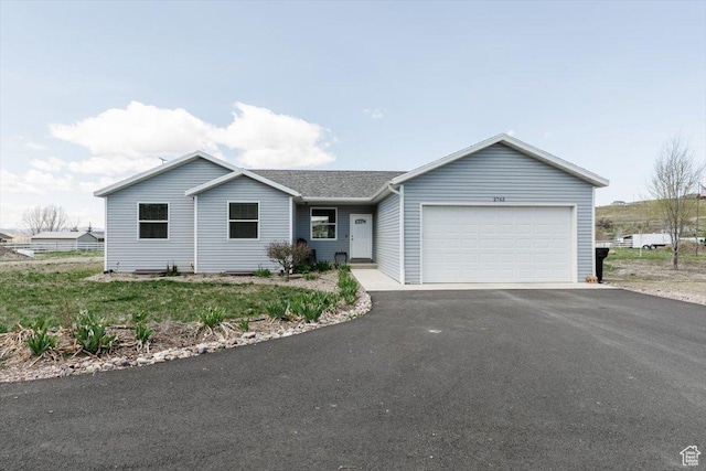 ranch-style house with an attached garage and aphalt driveway