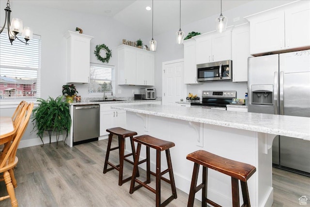 2763 E Read Ln, Preston, ID 83263 - kitchen with a sink, white cabinetry, light wood-style floors, a kitchen island, and appliances with stainless steel finishes