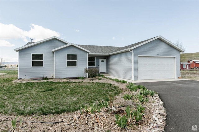 2763 E Read Ln, Preston, ID 83263 - ranch-style house featuring an attached garage, aphalt driveway, roof with shingles, and a front lawn