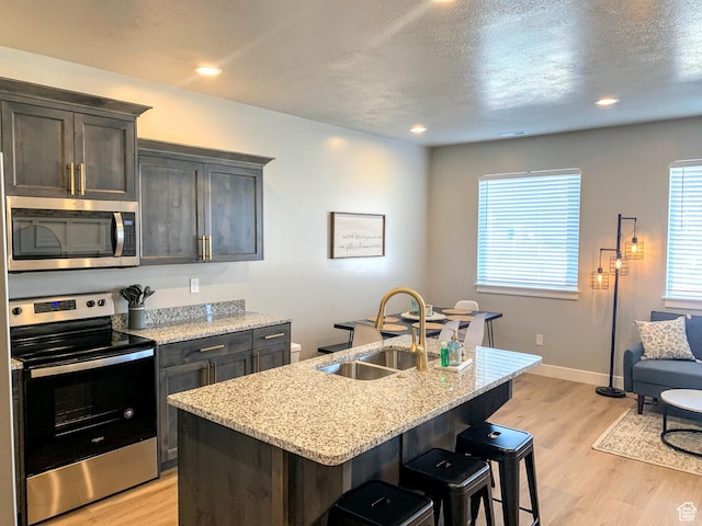 150 W Seasons Ln Unit 4, Garden City, UT 84028 - kitchen with light wood-style floors, a breakfast bar area, stainless steel appliances, and a sink