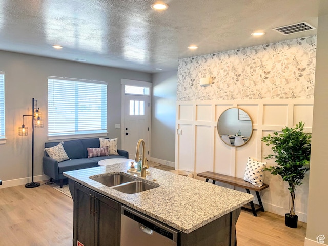 150 W Seasons Ln Unit 4, Garden City, UT 84028 - kitchen featuring stainless steel dishwasher, a decorative wall, a sink, light wood finished floors, and visible vents