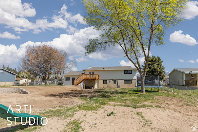 4351 W 1400 N, Plain City, UT 84404 - back of property with a wooden deck, stairway, fence, and a trampoline