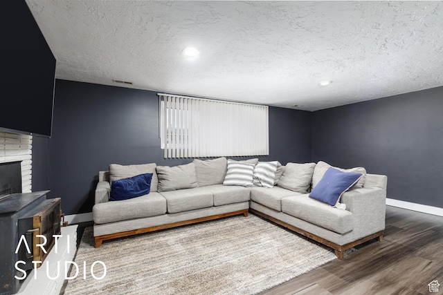4351 W 1400 N, Plain City, UT 84404 - living room featuring wood finished floors, a textured ceiling, a fireplace, baseboards, and visible vents