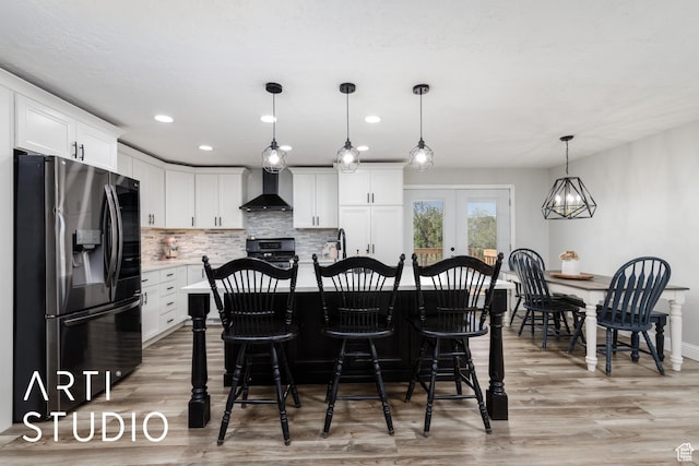 4351 W 1400 N, Plain City, UT 84404 - kitchen featuring light wood-type flooring, wall chimney exhaust hood, stainless steel fridge, range, and white cabinetry
