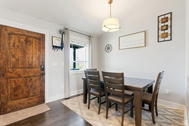 dining space featuring baseboards and wood finished floors