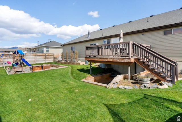 rear view of property with stairway, fence, a garden, a wooden deck, and a lawn