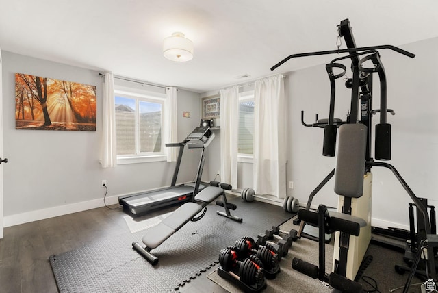 exercise area with baseboards and wood finished floors