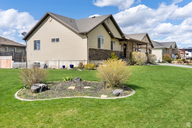 view of side of home featuring a lawn and stone siding