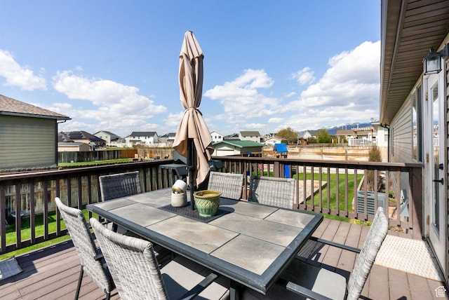 wooden deck featuring a residential view, a fenced backyard, and outdoor dining area