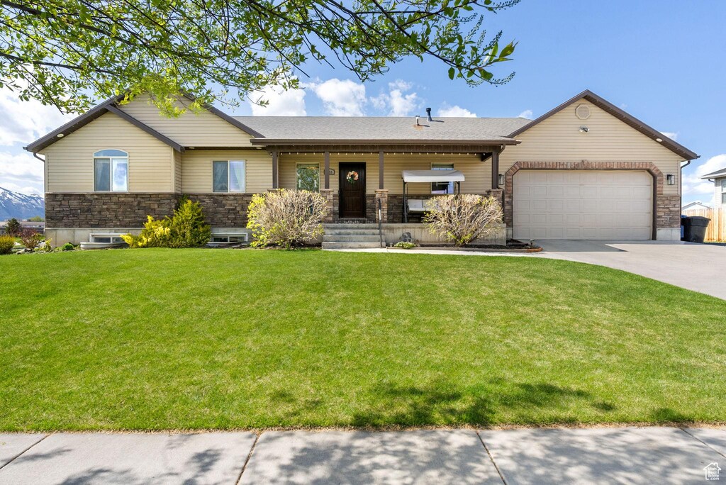 2355 S 1155 W, Nibley, UT 84321 - ranch-style home with an attached garage, stone siding, driveway, and a front yard