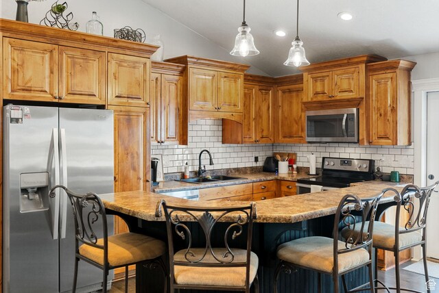kitchen featuring vaulted ceiling, a sink, stainless steel appliances, decorative light fixtures, and backsplash