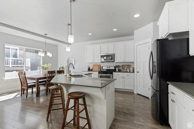 4941 W Chrome Rd, Herriman, UT 84096 - kitchen with a kitchen breakfast bar, a sink, appliances with stainless steel finishes, dark wood-style floors, and recessed lighting