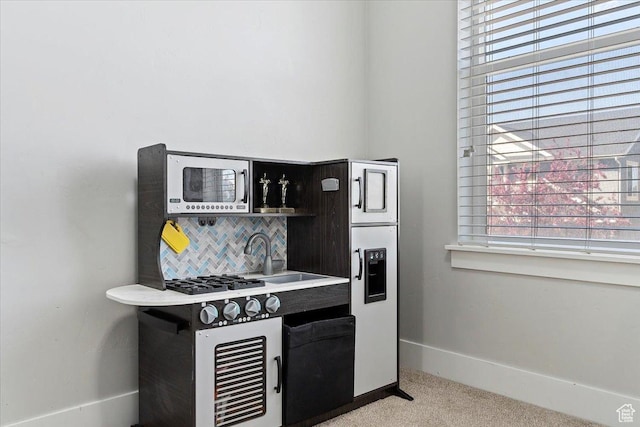 4941 W Chrome Rd, Herriman, UT 84096 - kitchen featuring a healthy amount of sunlight, a sink, carpet flooring, and tasteful backsplash