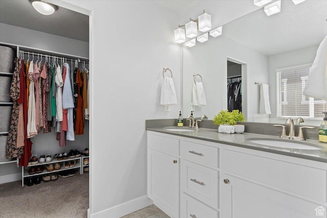 4941 W Chrome Rd, Herriman, UT 84096 - full bathroom featuring a walk in closet, double vanity, baseboards, and a sink