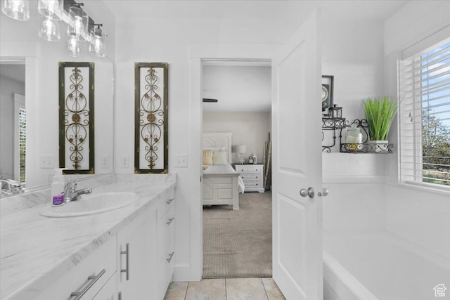 bathroom featuring a bath, vanity, tile patterned flooring, and plenty of natural light