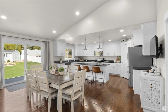 dining area featuring recessed lighting, dark wood finished floors, and high vaulted ceiling