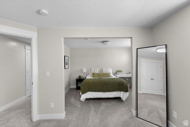 bedroom with carpet floors, a textured ceiling, and baseboards