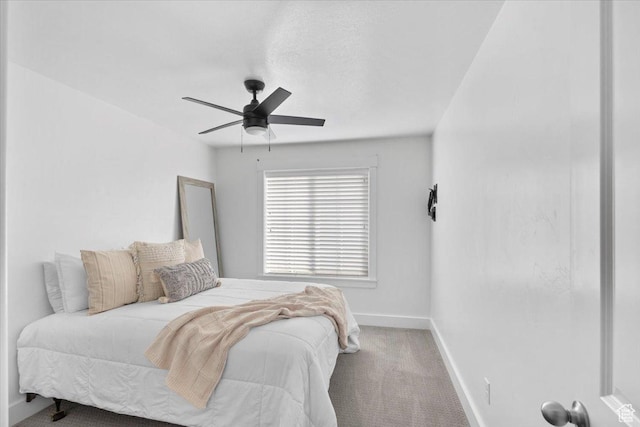 carpeted bedroom with a ceiling fan and baseboards