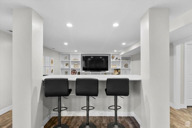 kitchen with recessed lighting, light countertops, wood finished floors, and baseboards
