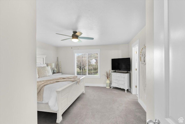 carpeted bedroom featuring baseboards and ceiling fan