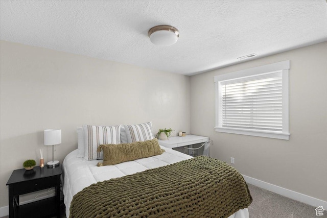 carpeted bedroom featuring baseboards, visible vents, and a textured ceiling