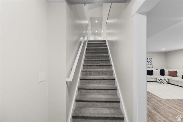staircase with baseboards, wood finished floors, and recessed lighting