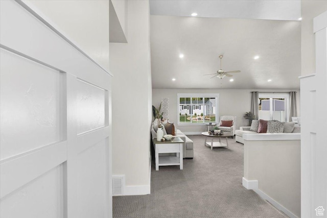 carpeted living area featuring baseboards, a ceiling fan, visible vents, and recessed lighting