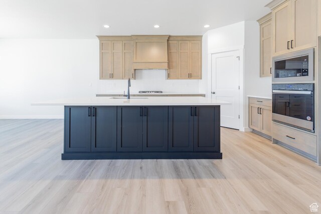 3080 N 2875 W Unit 25, Plain City, UT 84404 - kitchen featuring a sink, built in microwave, oven, light wood finished floors, and custom range hood