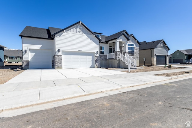 3080 N 2875 W Unit 25, Plain City, UT 84404 - view of front facade featuring a garage, driveway, stone siding, and board and batten siding