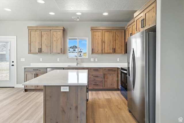 1273 S 240 W Lot 9, Tremonton, UT 84337 - kitchen with appliances with stainless steel finishes, recessed lighting, light wood finished floors, a kitchen island, and a textured ceiling