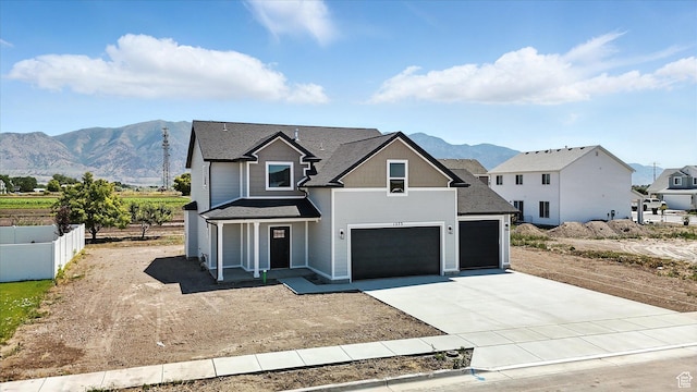 1273 S 240 W Lot 9, Tremonton, UT 84337 - view of front facade with driveway, a mountain view, a porch, a shingled roof, and an attached garage