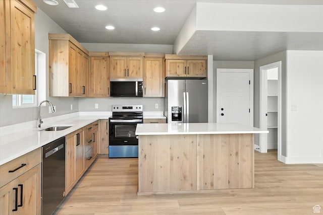 1273 S 240 W Lot 9, Tremonton, UT 84337 - kitchen featuring stainless steel appliances, light brown cabinetry, light wood-style floors, a kitchen island, and light countertops