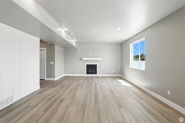 1273 S 240 W Lot 9, Tremonton, UT 84337 - unfurnished living room with light wood-style floors, a fireplace, and recessed lighting