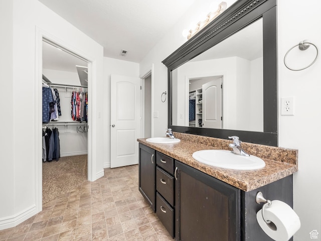 2046 N Belmont Dr, Saratoga Springs, UT 84045 - bathroom with visible vents, double vanity, a spacious closet, and a sink