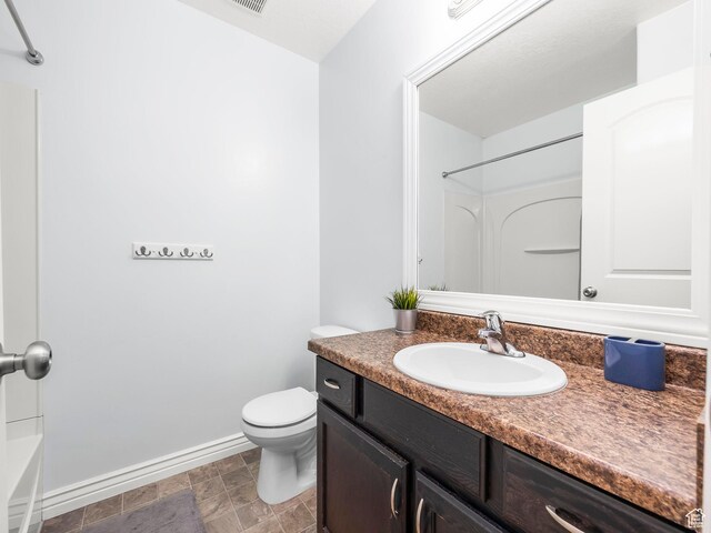 2046 N Belmont Dr, Saratoga Springs, UT 84045 - bathroom with baseboards, stone finish flooring, vanity, and toilet