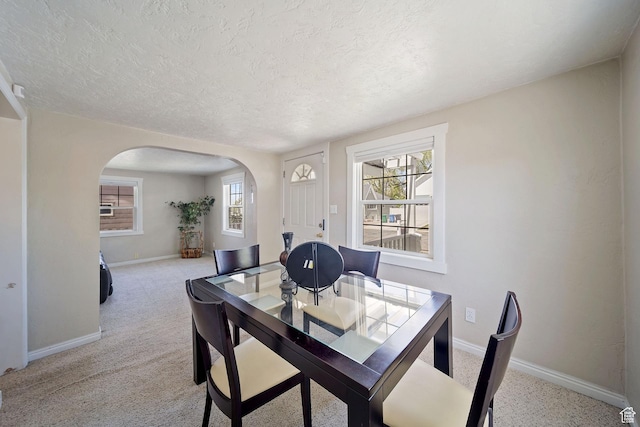 730 E 3155 S, Millcreek, UT 84106 - dining space featuring baseboards, arched walkways, a textured ceiling, and light colored carpet