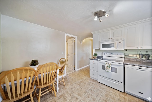 730 E 3155 S, Millcreek, UT 84106 - kitchen with arched walkways, dark countertops, white cabinetry, and white appliances