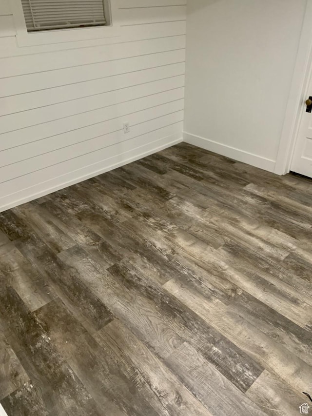 unfurnished bedroom with dark wood finished floors and baseboards