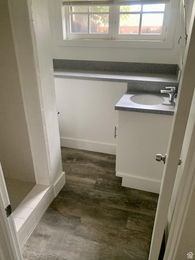 bathroom featuring a shower stall, vanity, and wood finished floors