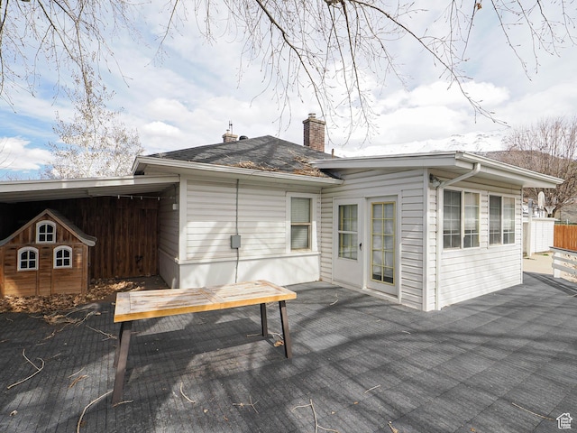 back of property featuring a patio and a chimney