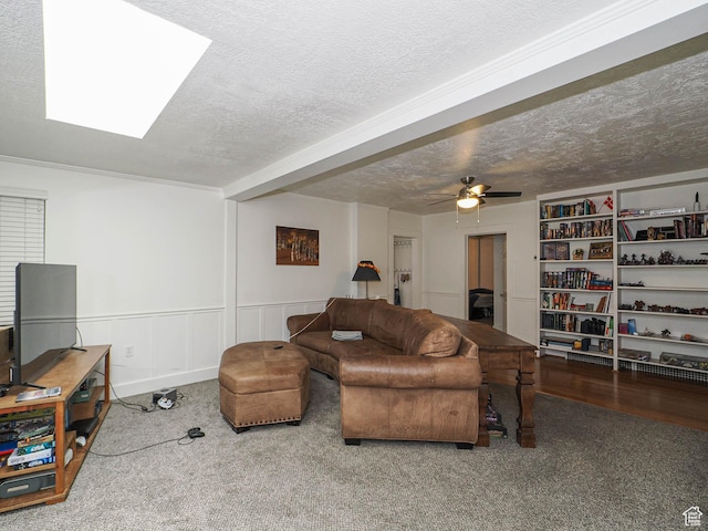 living area featuring carpet, a textured ceiling, and a ceiling fan