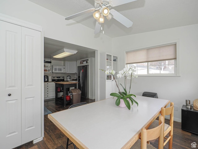 dining space featuring a ceiling fan and dark wood-style flooring