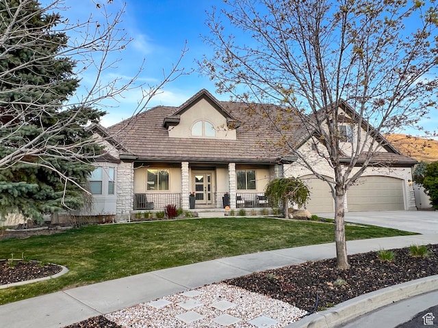 14661 S Rock Canyon Cir W, Herriman, UT 84096 - view of front of house with stucco siding, covered porch, driveway, and a front lawn