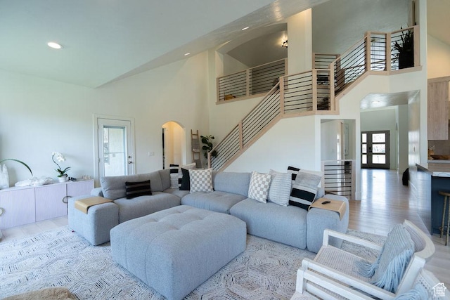 14661 S Rock Canyon Cir W, Herriman, UT 84096 - living room featuring a high ceiling, arched walkways, stairs, wood finished floors, and recessed lighting