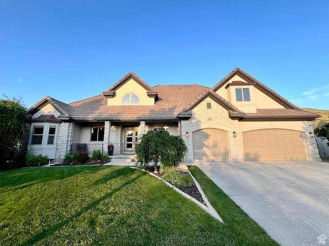14661 S Rock Canyon Cir W, Herriman, UT 84096 - view of front of house featuring stone siding, stucco siding, covered porch, and driveway