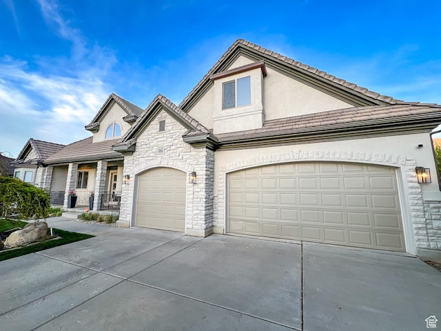 14661 S Rock Canyon Cir W, Herriman, UT 84096 - view of front facade featuring stone siding, driveway, stucco siding, and a tiled roof