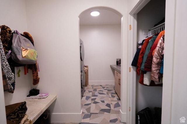 14661 S Rock Canyon Cir W, Herriman, UT 84096 - walk in closet with stacked washer / drying machine, arched walkways, and light floors
